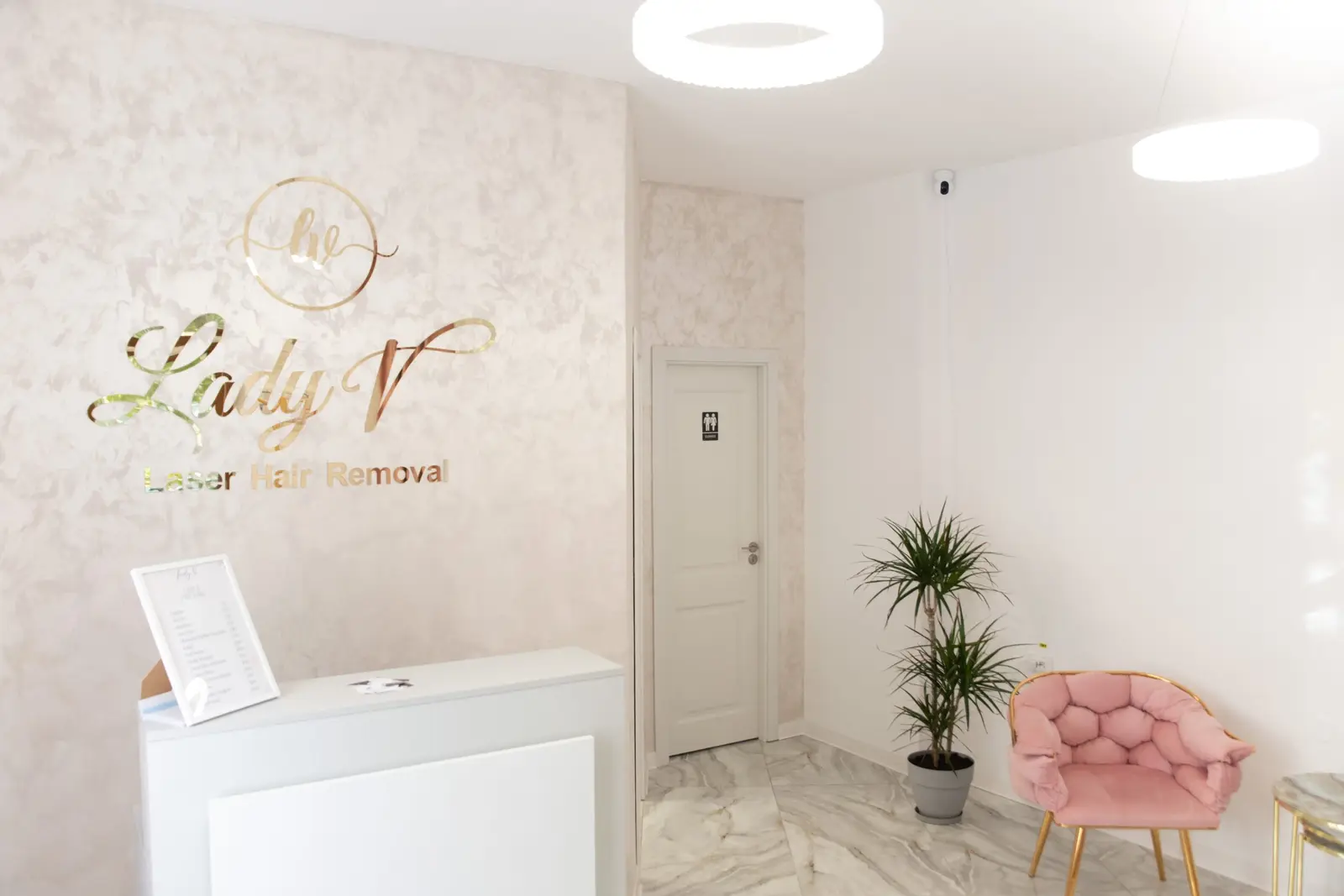 Recepția salonului Lady V din Brăila — fotoliu roz și siglă aurie